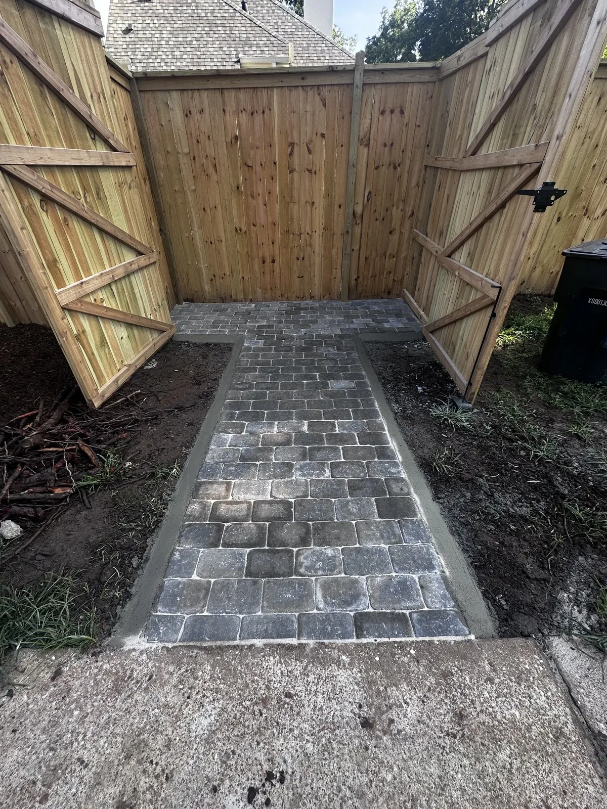 Stone paver walkway through a wooden gate