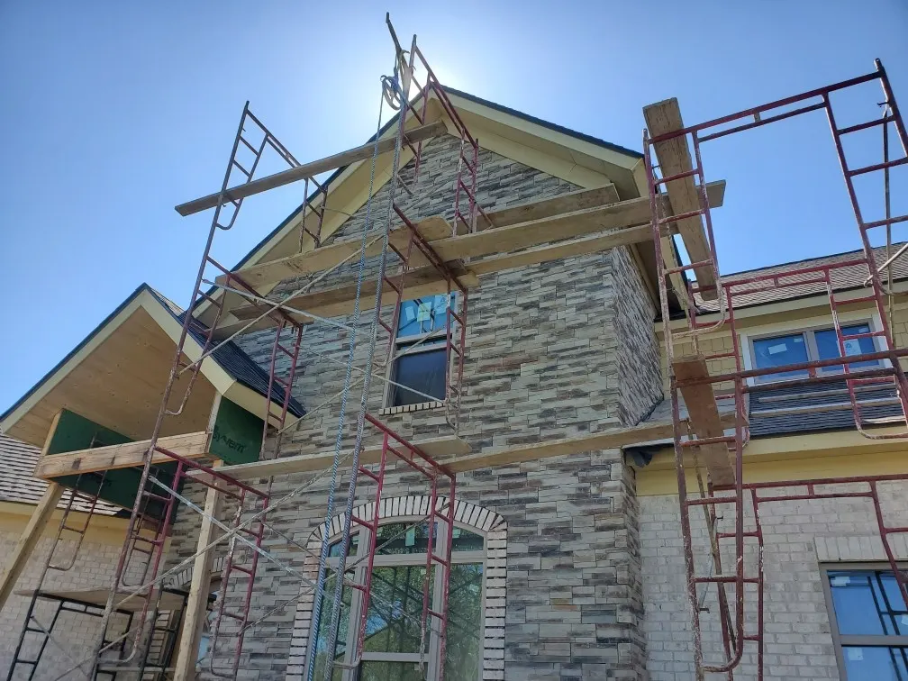Brick and stone home exterior masonry under construction